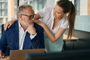 Young woman flirting with mature boss in office