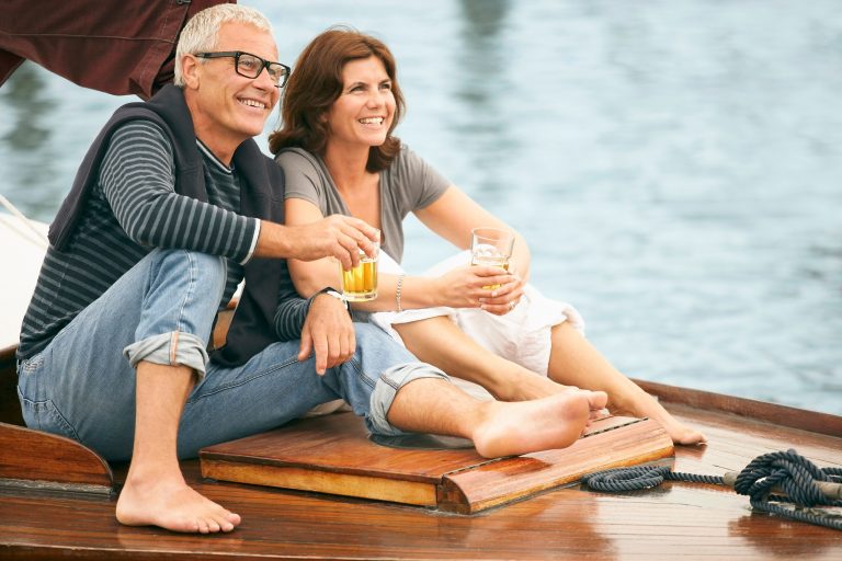 Middle aged couple drinking on boat