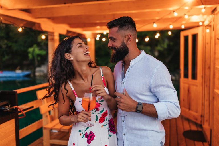 Smiling couple celebrating with wine
